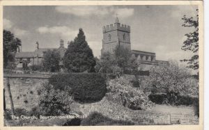 The view of a church tower seen behind a stone wall and trees